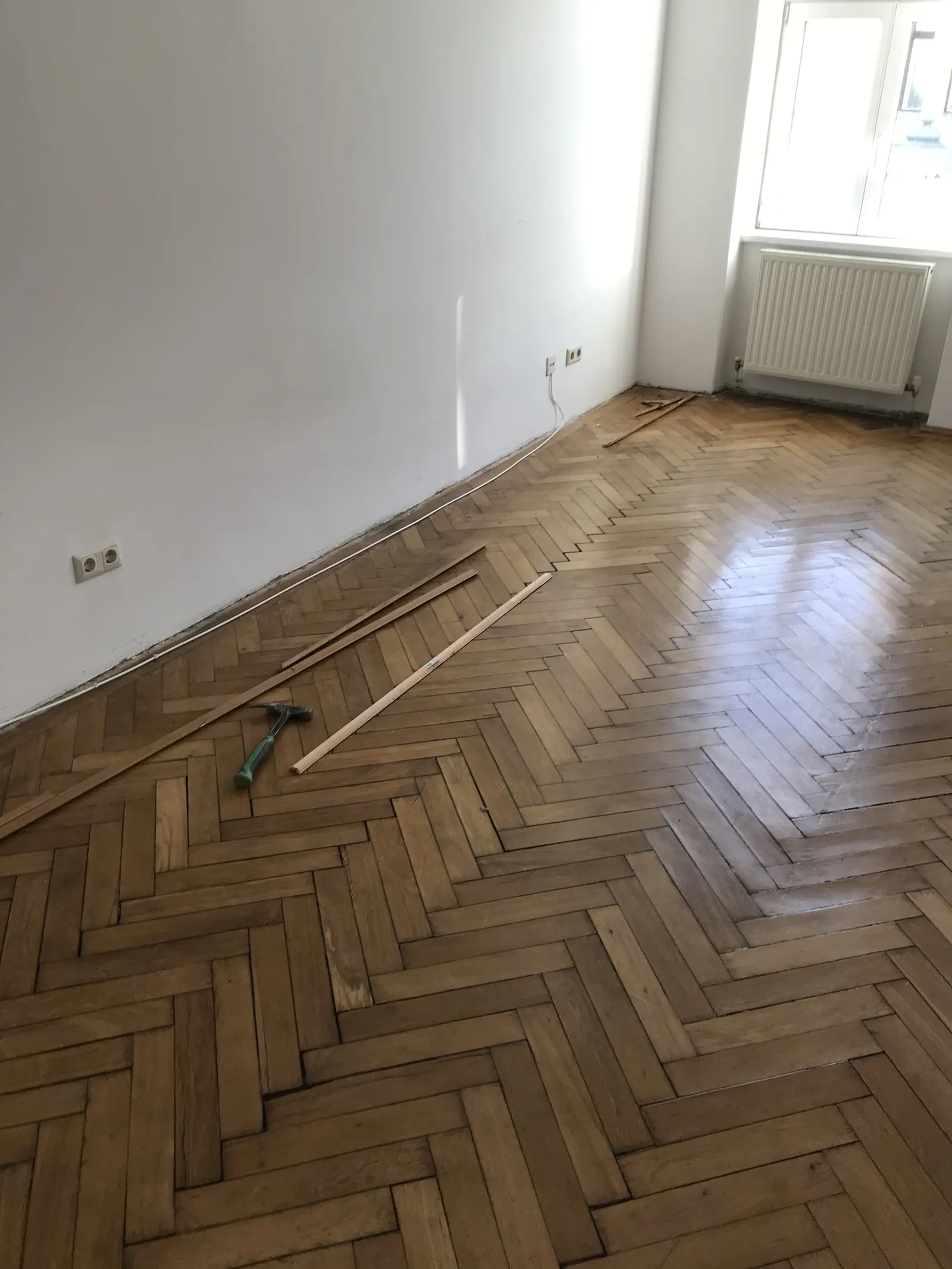 Entrümpelter Altbauraum mit Fischgrätparkett